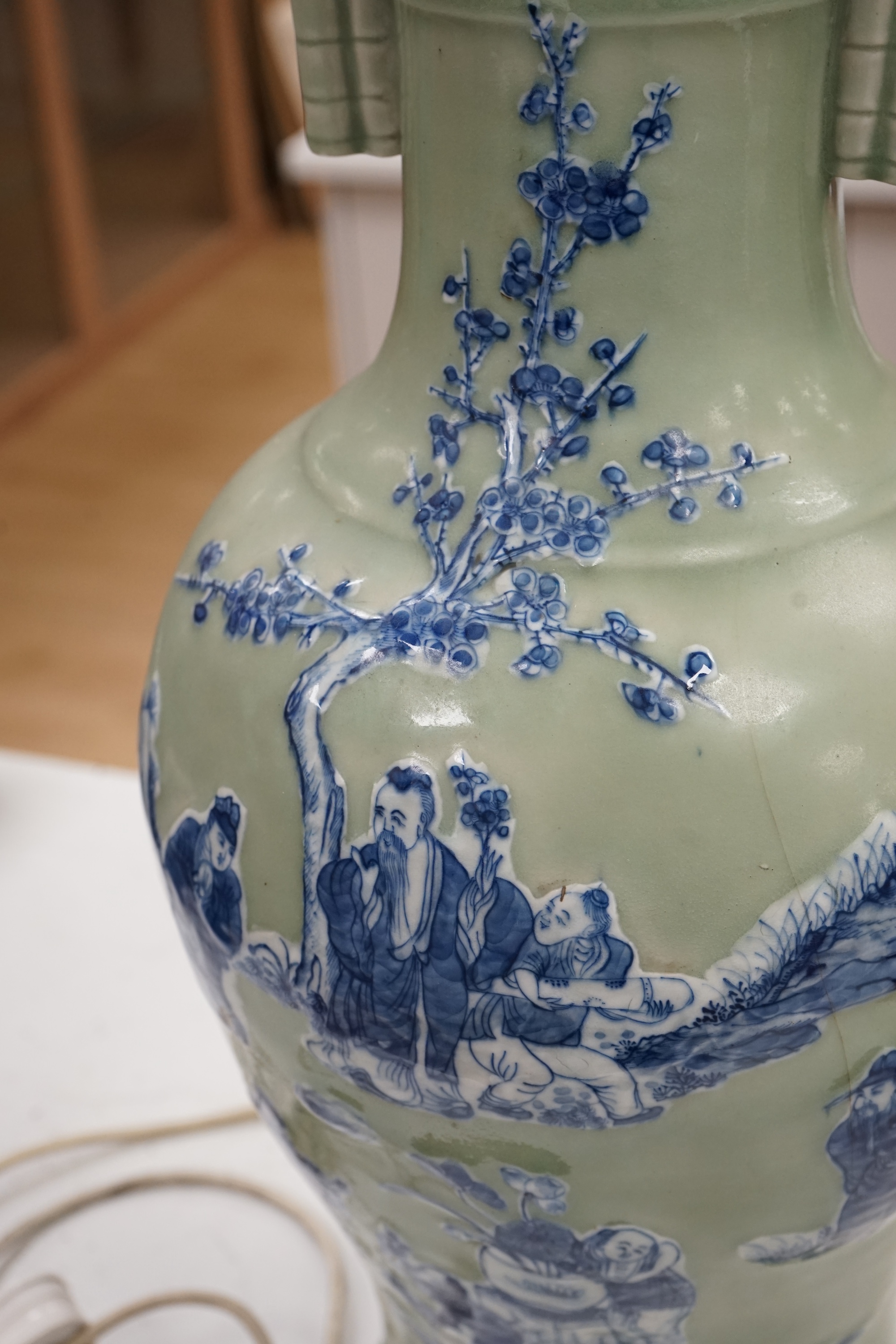 A large Chinese underglaze blue and slip decorated celadon ground vase, converted to a lamp, 61cm high. Condition - a crack 16cm down the side of the body